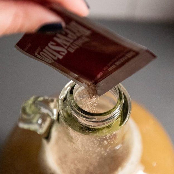 Pouring packet of Beer Yeast into a full fermentation jar. 